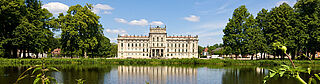 Schloss Ludwigslust mit Teich und Parklandschaft an einem sonnigen Tag.