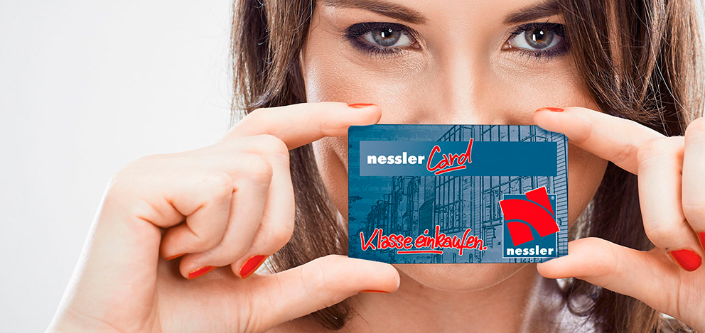 Frau hält eine nesslerCard vor ihr Gesicht und blickt in die Kamera.